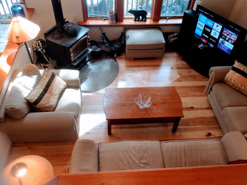 Main living room with a sectional sofa, a wood stove and a TV