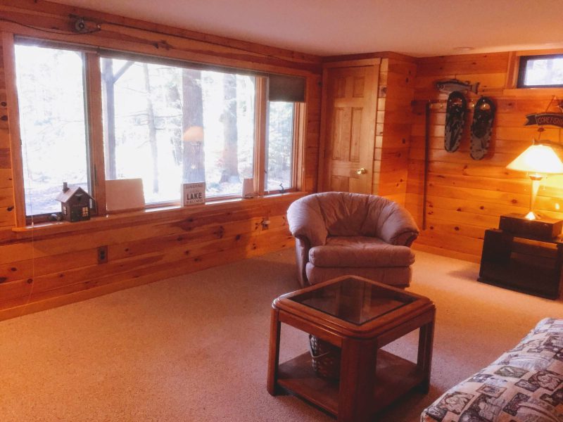 Knotty pine room with a chair; the snowshoes on the wall are decoration