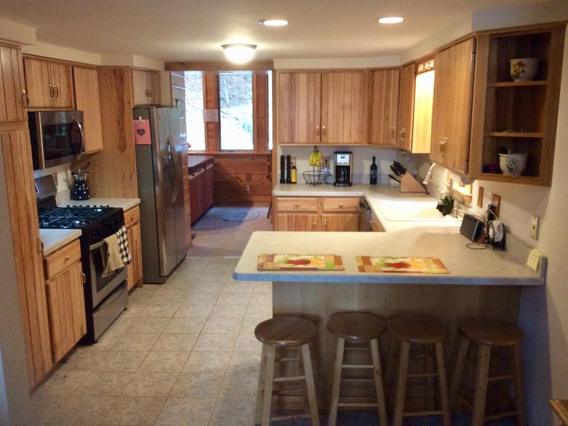 Wide view of the kitchen with an island and bar stools